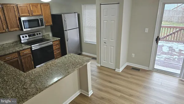 a kitchen with stainless steel appliances granite countertop a refrigerator microwave and sink