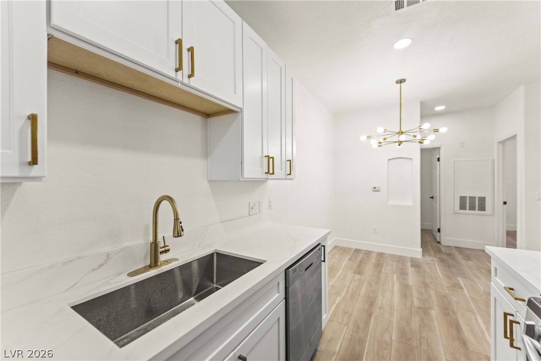 4730 East Craig Road, Unit 1053 Las Vegas, NV 89115 - Photo 7 of 32 A well-appointed kitchen showcasing elegant cabinetry and a modern gold-toned faucet over a sleek sink.