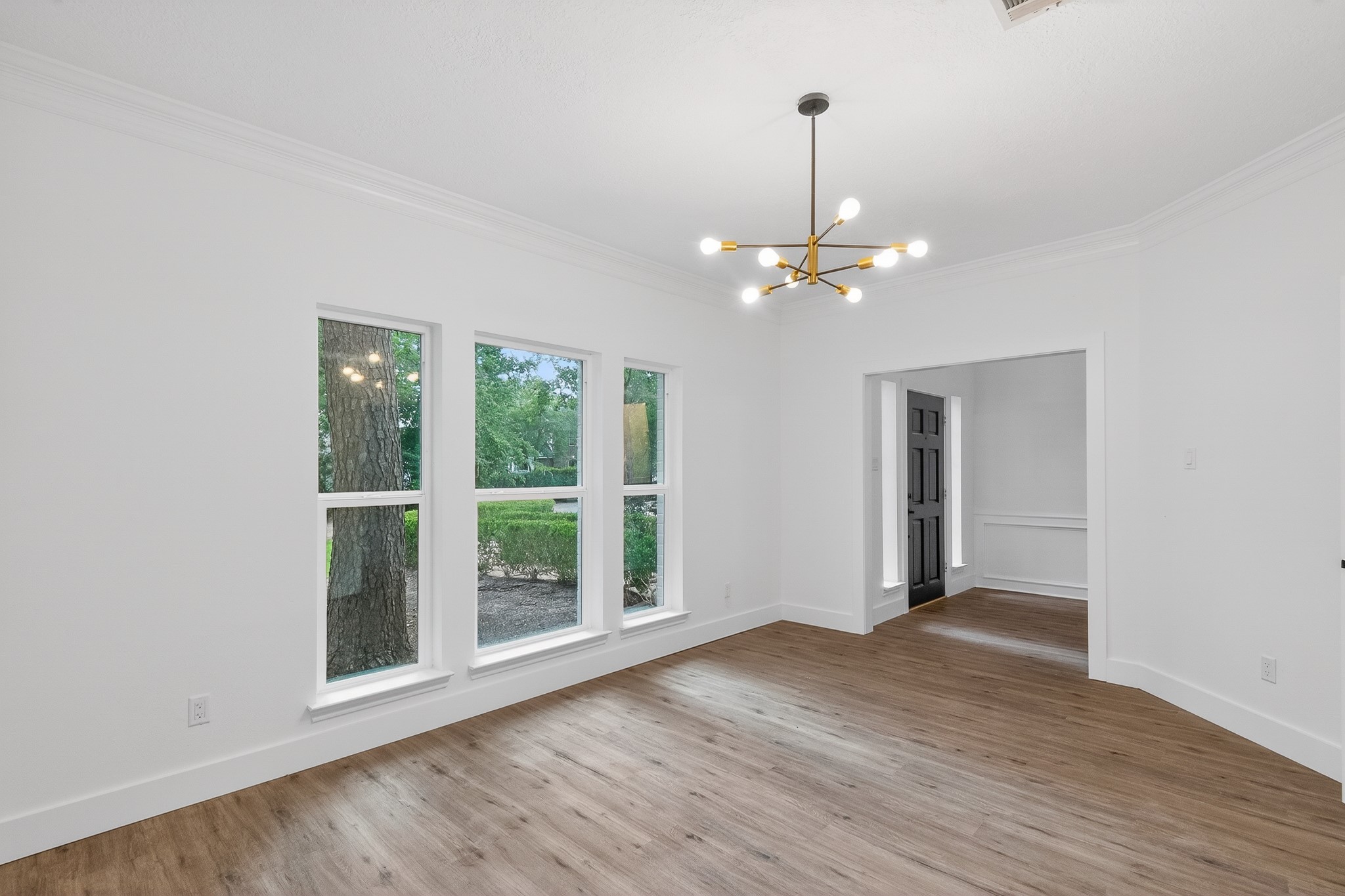 523 Rampart Lane Conroe, TX 77302 - Photo 7 of 41 Elegant dining space showcasing modern designer lighting, abundant natural light, premium flooring, and a versatile layout perfect for memorable gatherings and sophisticated entertaining.