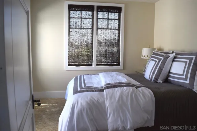 a bed sitting in a bedroom next to a window