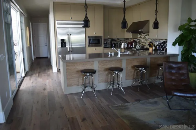 a kitchen with stainless steel appliances granite countertop a refrigerator a stove and a wooden floors