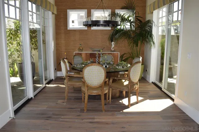 a dining room with furniture a chandelier and wooden floor