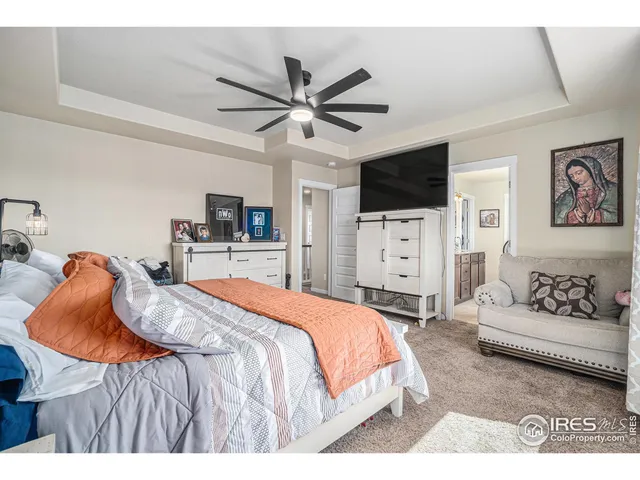 a bedroom with a bed a flat screen tv and a couch