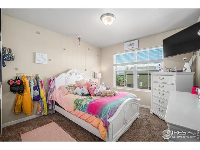 a bedroom with a bed and a flat tv screen on dresser