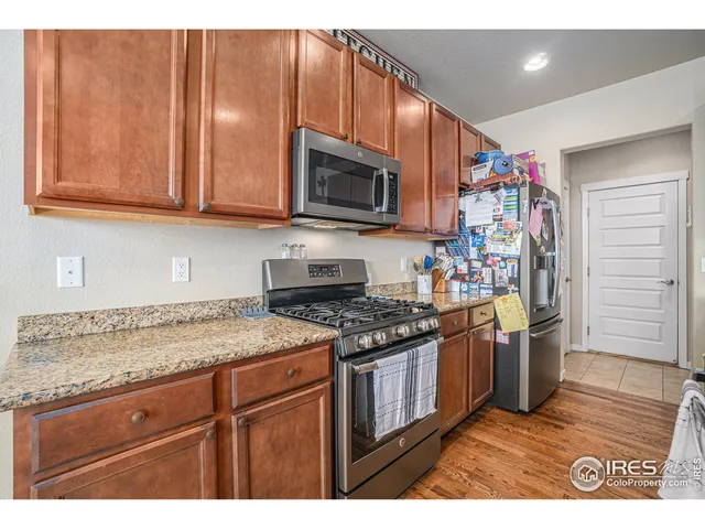 a kitchen with stainless steel appliances granite countertop wooden cabinets a stove top oven a sink and dishwasher