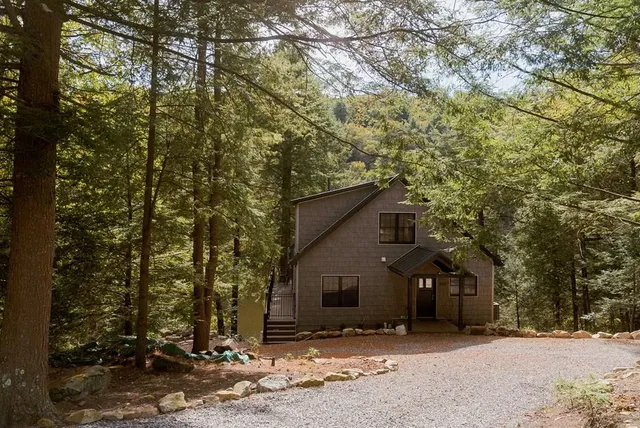 a front view of a house with a yard covered in snow