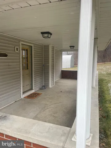 a view of a hallway with wooden floor and a room