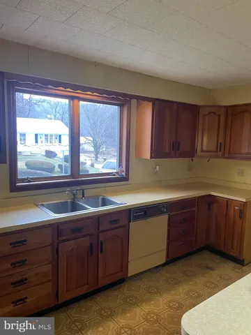 a kitchen with stainless steel appliances granite countertop wooden cabinets a sink and dishwasher with wooden floor