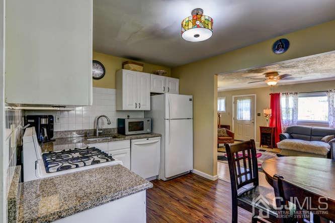 50 Ashley Road Edison, NJ 08817 - Photo 10 of 25 a kitchen with a stove a refrigerator and a dining table