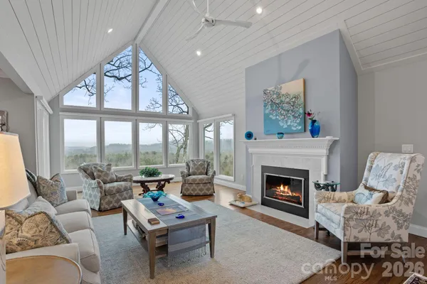 a living room with furniture a fireplace and a large window