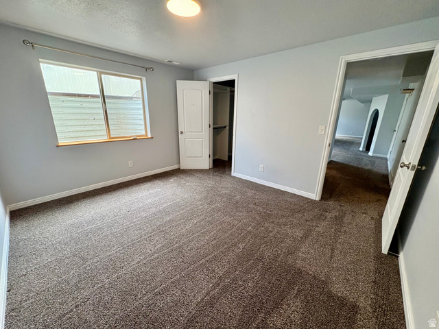 665 West State Road Lehi, UT 84043 - Photo 18 of 30 Carpeted room with light gray walls, a window with wood trim, a built-in closet with bifold doors, and a ceiling-mounted light fixture