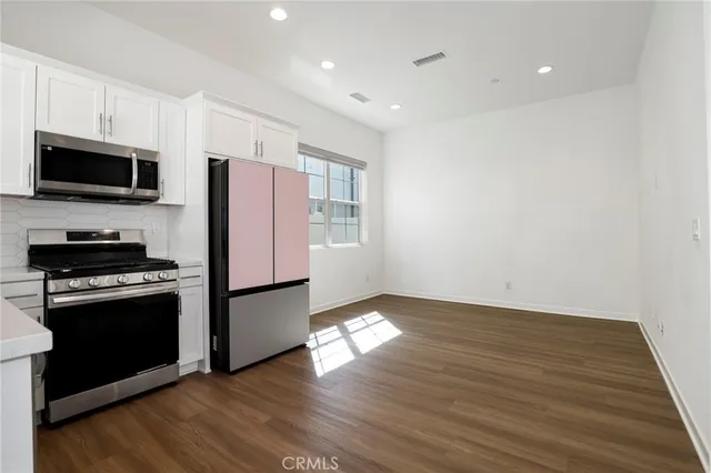 an empty room with windows and chandelier fan