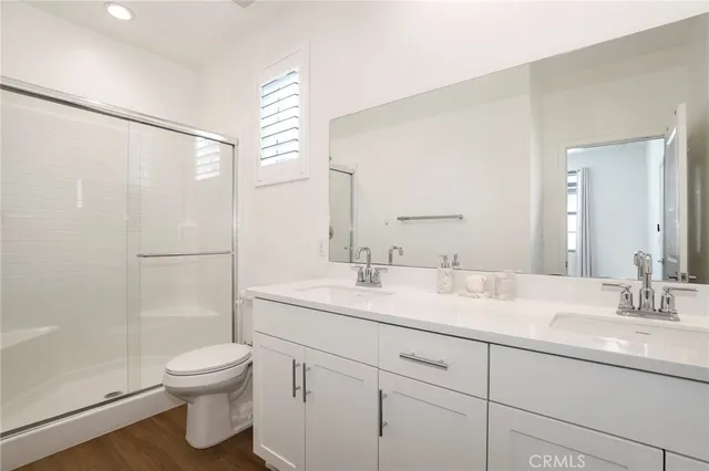 a bathroom with a toilet sink and mirror with window