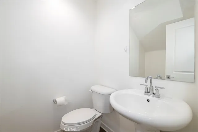 a view of staircase with lots of frames on wall and wooden floor