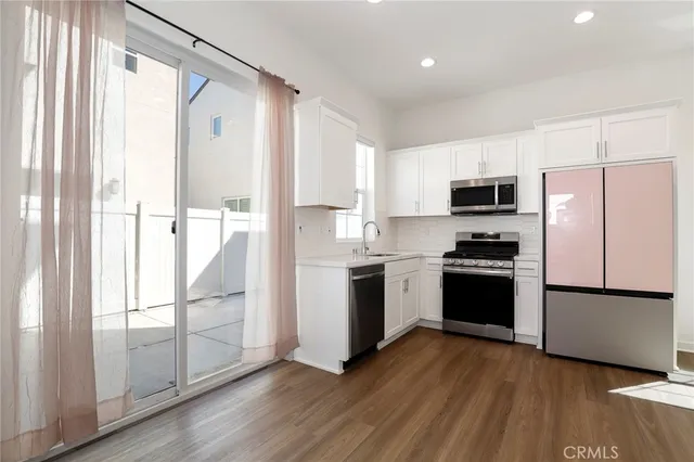 a kitchen with a refrigerator and a stove top oven