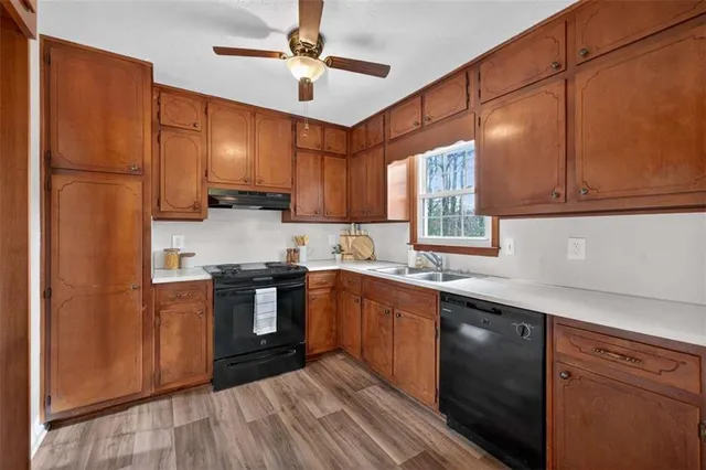 a kitchen with stainless steel appliances granite countertop a stove a sink dishwasher a refrigerator and cabinets with wooden floor