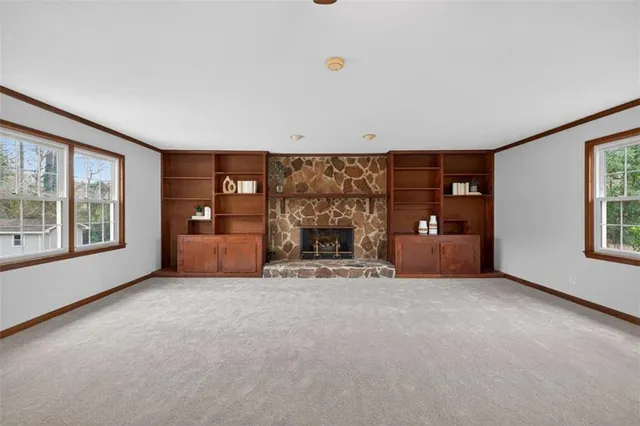 a view of an empty room with a fireplace and a window