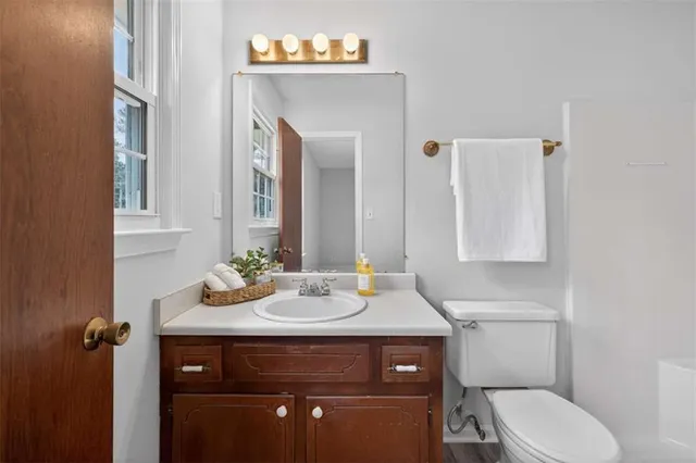 a bathroom with a toilet sink and mirror