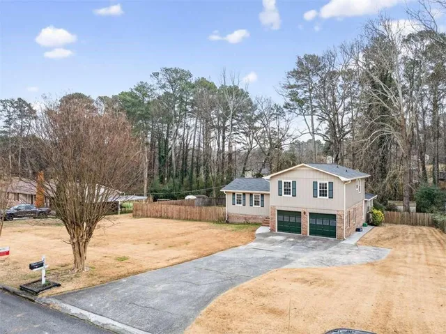 a front view of a house with a yard and trees