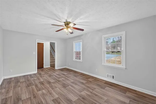 a view of an empty room with a window and a chandelier fan