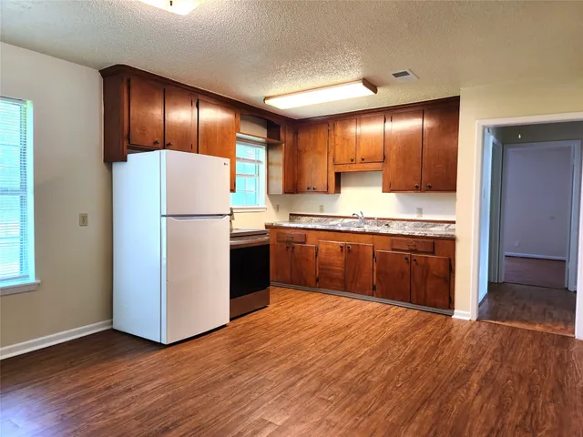 a kitchen with kitchen island wooden cabinets stainless steel appliances and window
