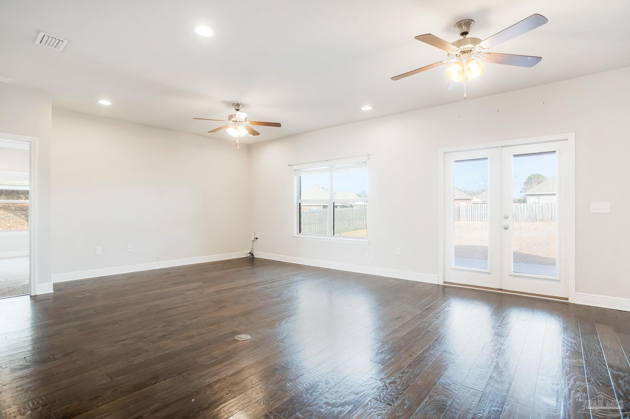 8016 Woodbrook Road Pensacola, FL 32526 - Photo 15 of 52 a view of an empty room with wooden floor and a ceiling fan