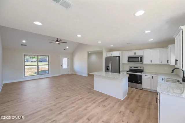 a view of kitchen with microwave a stove and wooden floor