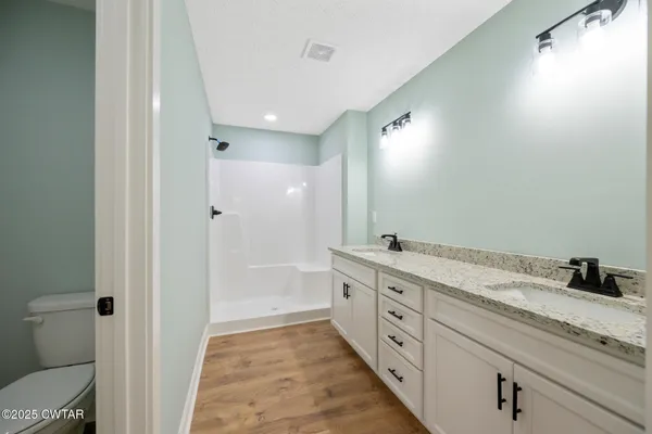 a spacious bathroom with a granite countertop sink mirror and a toilet
