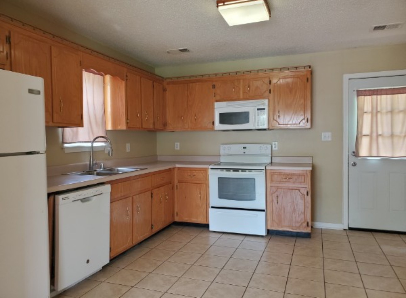 1058 Shadow Ridge Avenue Oak Grove, KY 42262 - Photo 4 of 7 a kitchen with a stove sink and cabinets