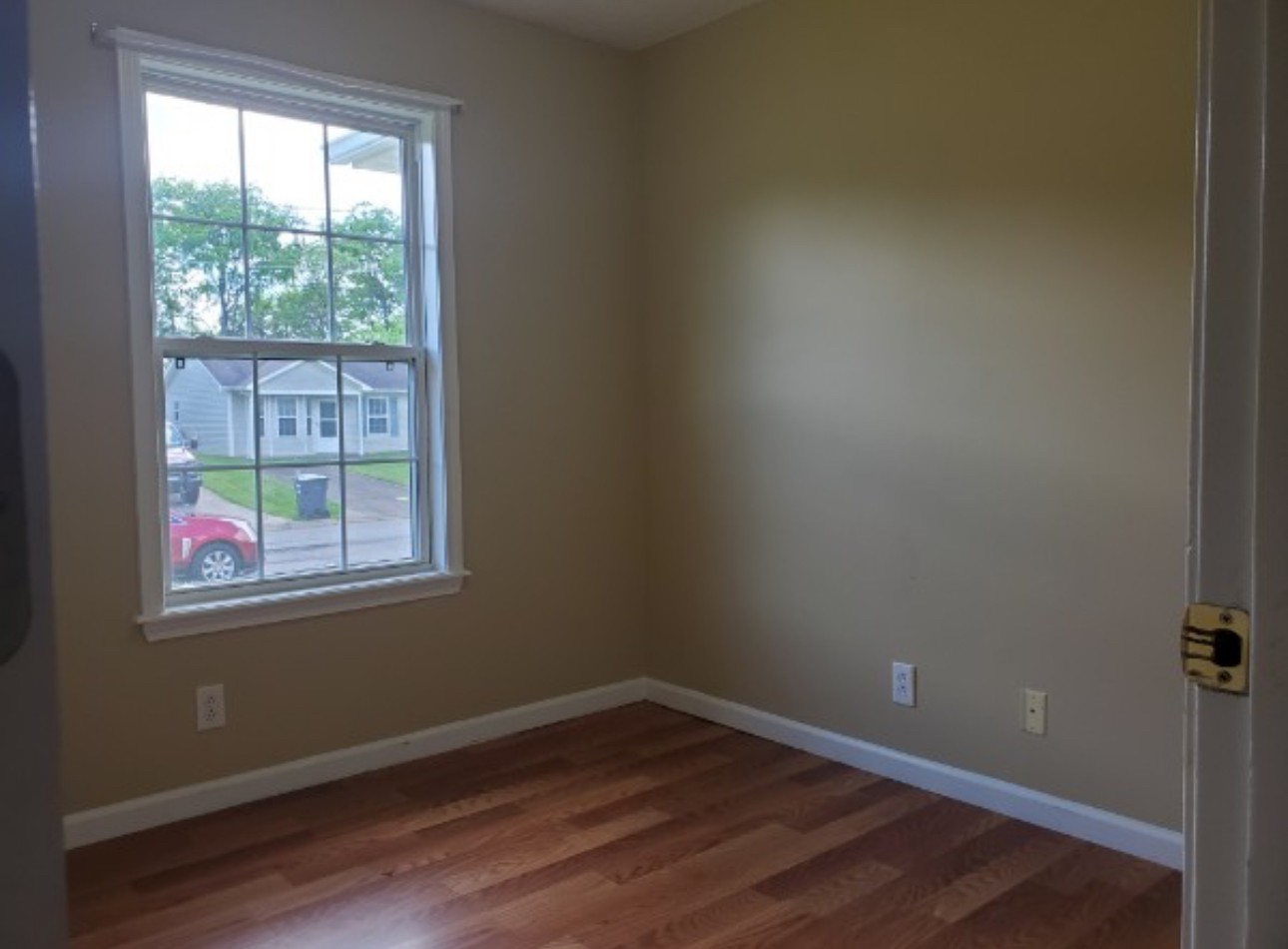 1058 Shadow Ridge Avenue Oak Grove, KY 42262 - Photo 6 of 7 a view of an empty room with wooden floor and a window
