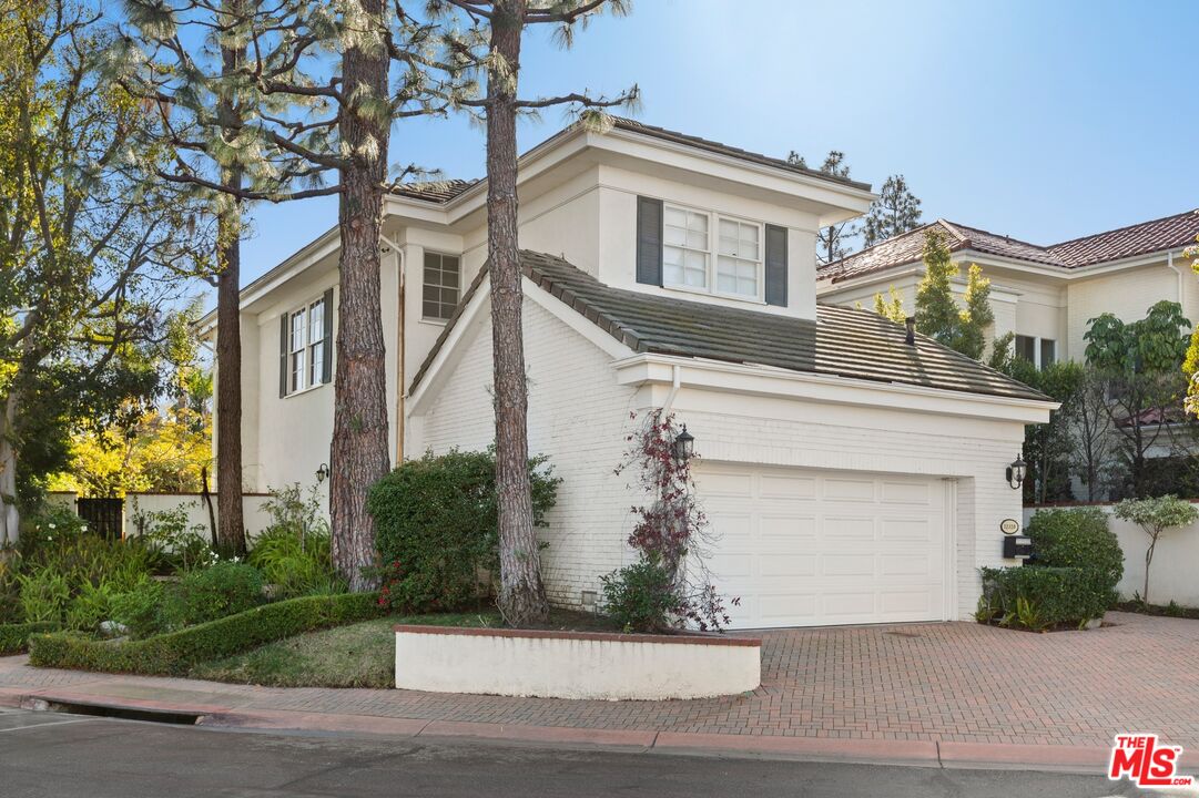 12320 Ridge Circle Los Angeles, CA 90049 - Photo 1 of 38 a front view of a house with a yard and garage
