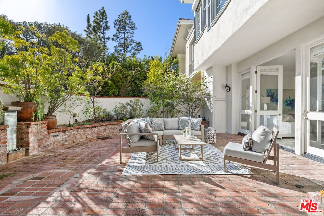 12320 Ridge Circle Los Angeles, CA 90049 - Photo 13 of 38 a view of a patio with couches and table and chairs and potted plants