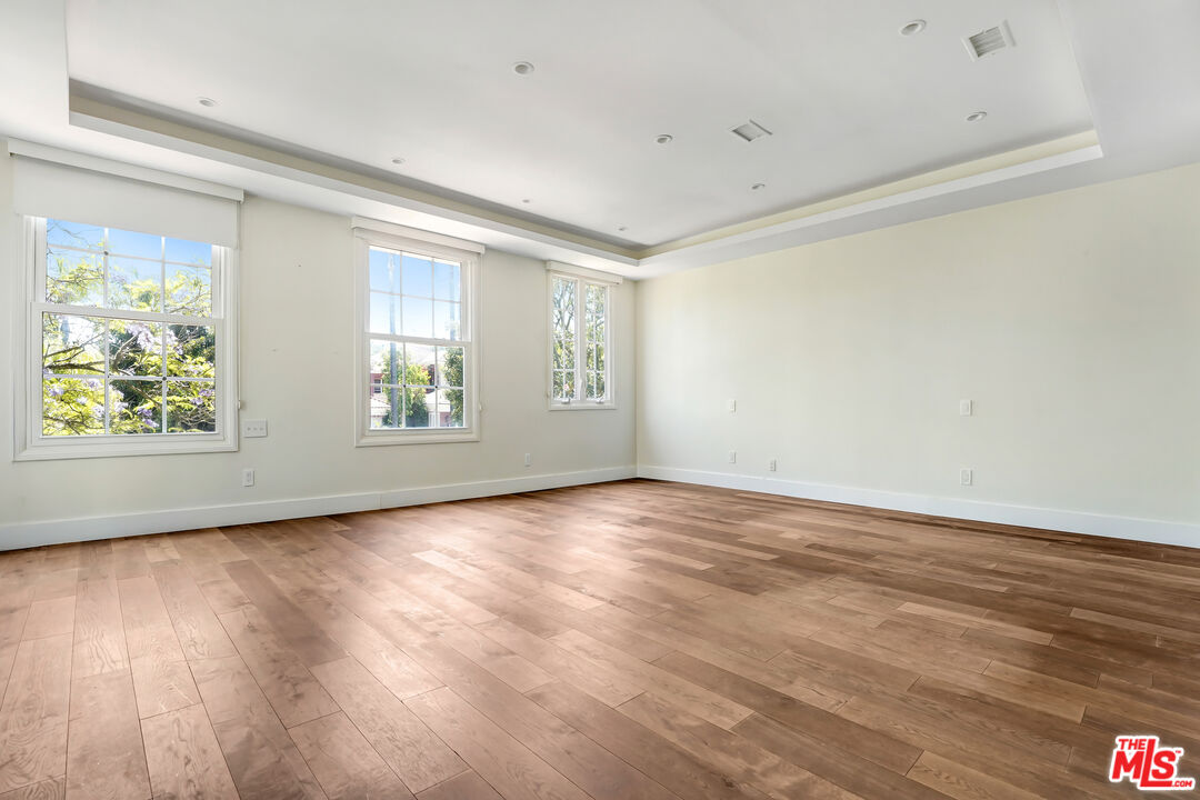 12320 Ridge Circle Los Angeles, CA 90049 - Photo 19 of 38 an empty room with wooden floor and windows