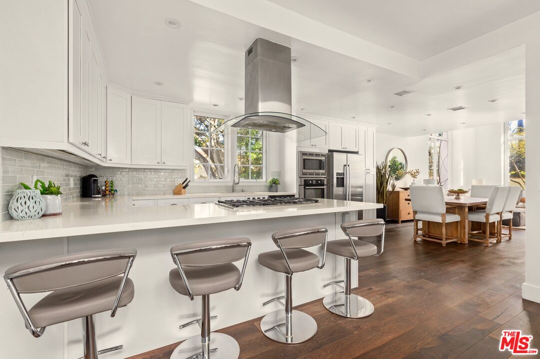 12320 Ridge Circle Los Angeles, CA 90049 - Photo 5 of 38 a kitchen with stainless steel appliances kitchen island granite countertop a table and chairs in it