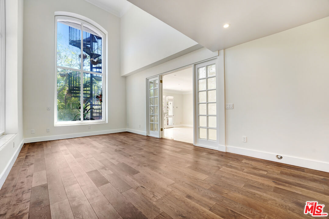 12320 Ridge Circle Los Angeles, CA 90049 - Photo 6 of 38 a view of an empty room with wooden floor and a window