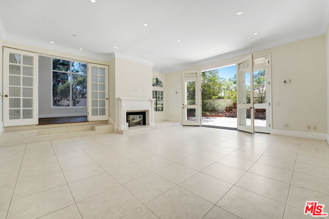 12320 Ridge Circle Los Angeles, CA 90049 - Photo 10 of 38 a view of an empty room with a fireplace and a large window