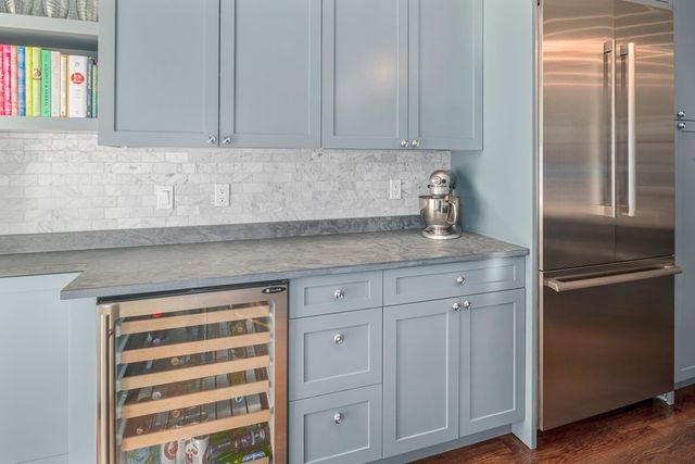 a kitchen with granite countertop a refrigerator and cabinets