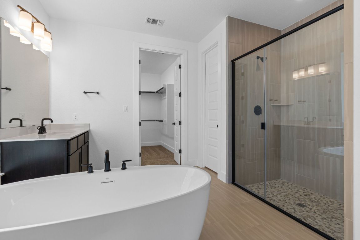 1620 Lilly Grace Bend Leander, TX 78641 - Photo 19 of 40 a large bathroom with a tub shower and sink