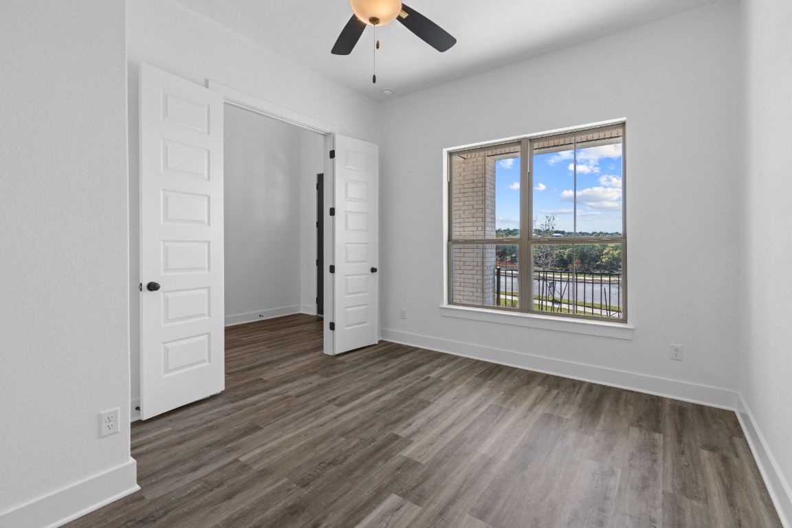 1620 Lilly Grace Bend Leander, TX 78641 - Photo 27 of 40 an empty room with wooden floor chandelier fan and windows