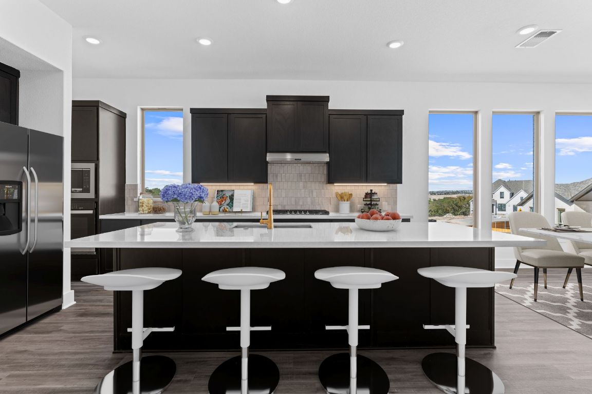 1620 Lilly Grace Bend Leander, TX 78641 - Photo 4 of 40 a kitchen with granite countertop a sink and chairs