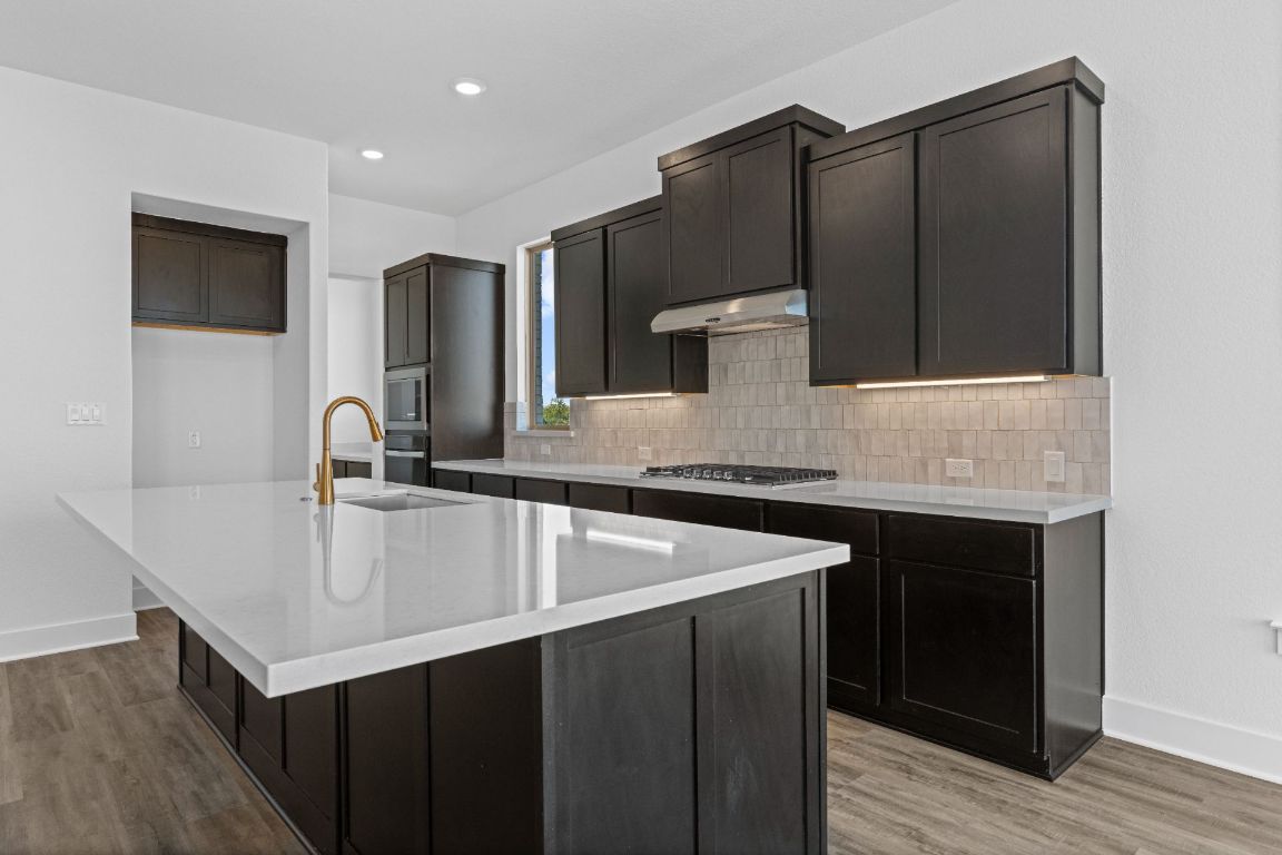 1620 Lilly Grace Bend Leander, TX 78641 - Photo 8 of 40 a kitchen with a sink cabinets and wooden floor