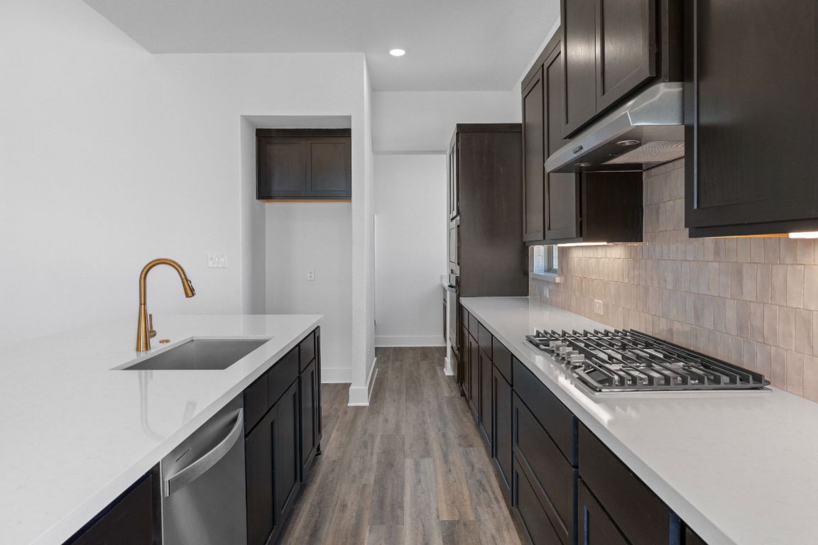 1620 Lilly Grace Bend Leander, TX 78641 - Photo 10 of 40 a kitchen with stainless steel appliances a sink stove and refrigerator