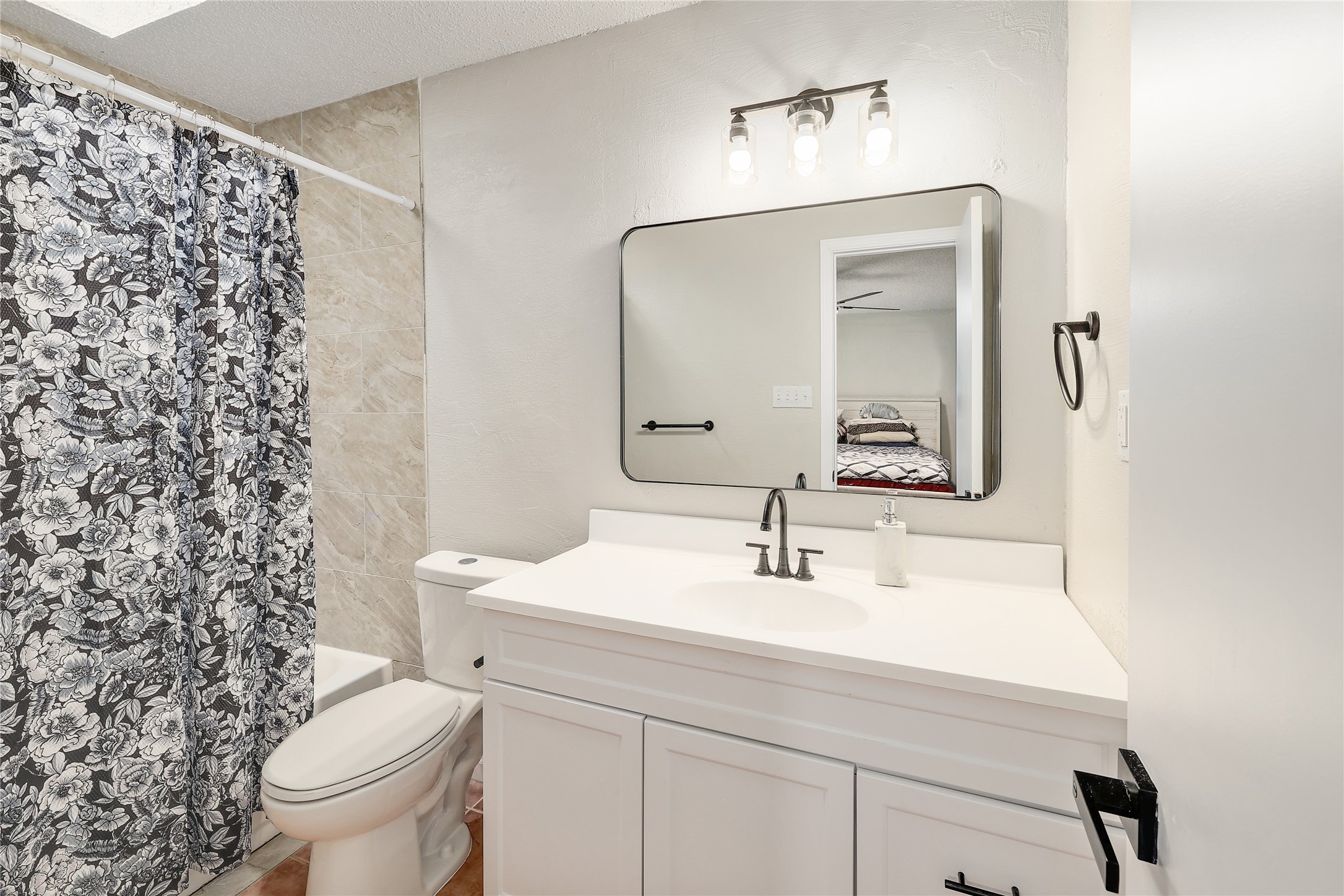 9906 Parliament House Road Austin, TX 78729 - Photo 13 of 33 Tiled shower walls and a crisp vanity basin enhance this classic bathroom design.