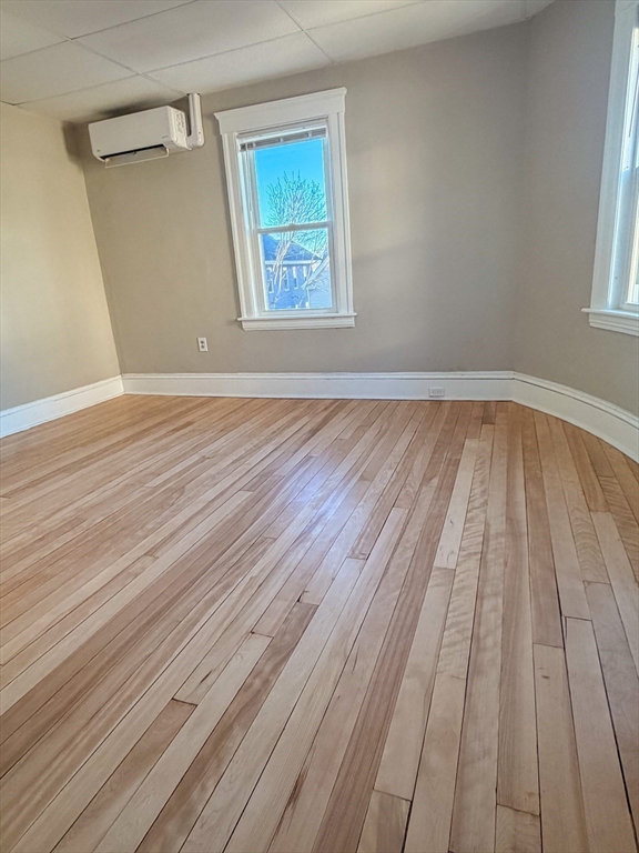 4 Vernon Terrace, Unit 2 Worcester, MA 01610 - Photo 2 of 12 an empty room with wooden floor and windows