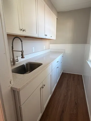 a kitchen with granite countertop white cabinets and sink