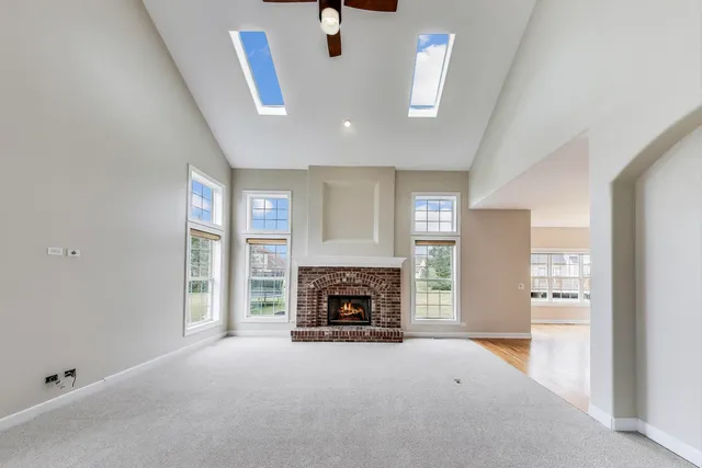 an empty room with windows and fireplace
