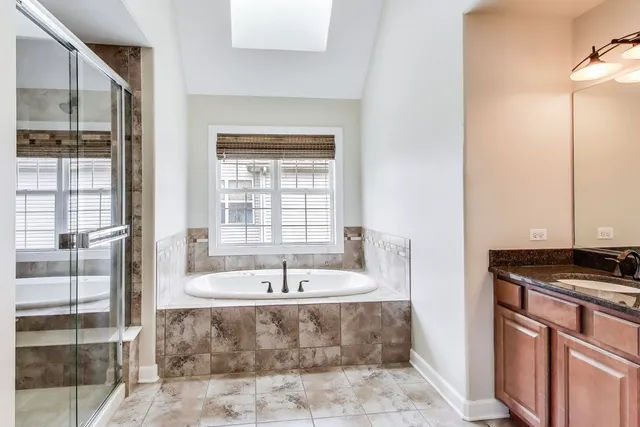 a bathroom with a tub sink and mirror