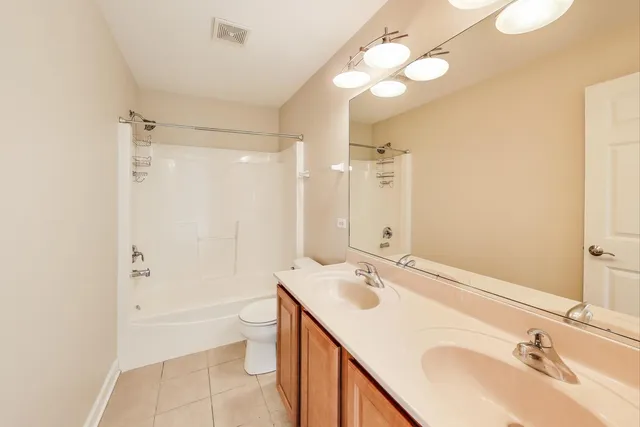 a bathroom with a sink double vanity granite tub and a mirror