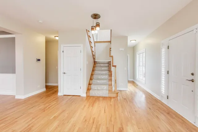 a view of a hallway with wooden floor and staircase
