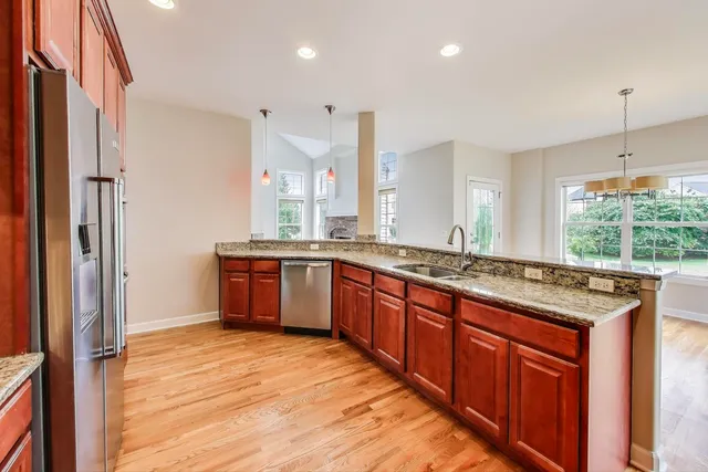 a large kitchen with stainless steel appliances granite countertop a stove and a sink